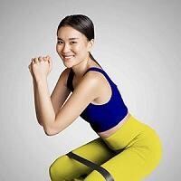 Woman doing squats wearing a resistance band